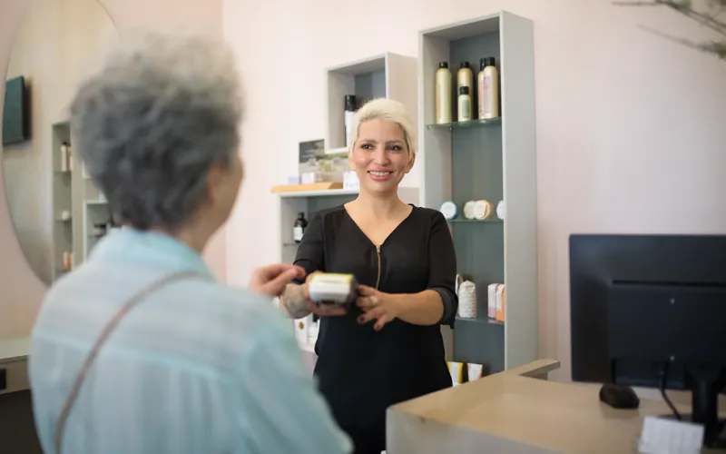 Professionnelle échangeant avec une cliente à l’accueil d’un salon