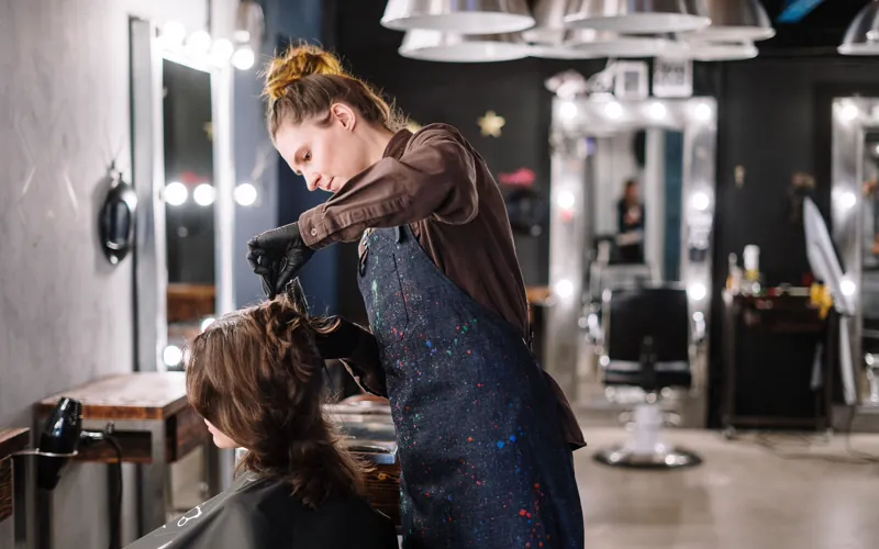 Coiffeuse appliquant une coloration pendant un rendez-vous au salon